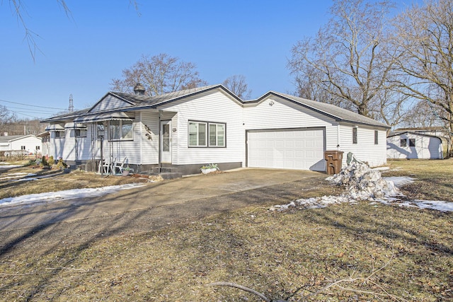 ranch-style house featuring aphalt driveway, entry steps, and an attached garage