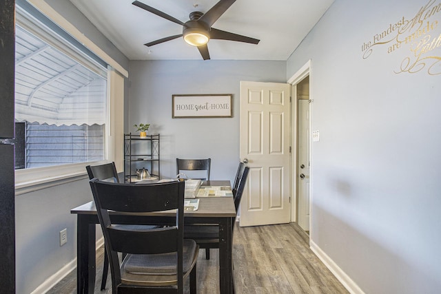 dining space featuring ceiling fan, baseboards, and wood finished floors