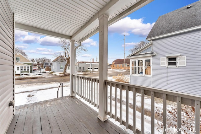 snow covered deck with a residential view