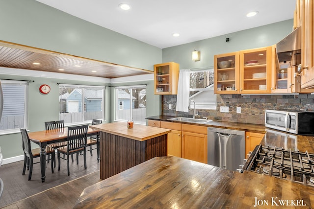 kitchen with dark wood-style floors, appliances with stainless steel finishes, glass insert cabinets, a sink, and wood counters