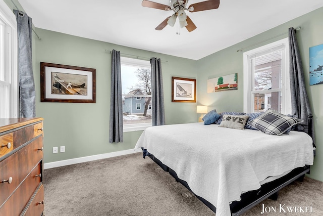 carpeted bedroom featuring multiple windows, baseboards, and a ceiling fan