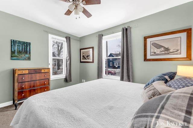 bedroom featuring a ceiling fan, carpet, multiple windows, and baseboards