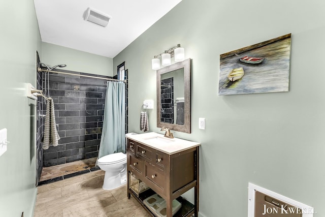 bathroom with toilet, a stall shower, vanity, and visible vents