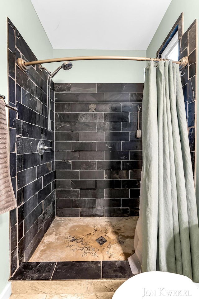 full bath featuring a shower stall and toilet