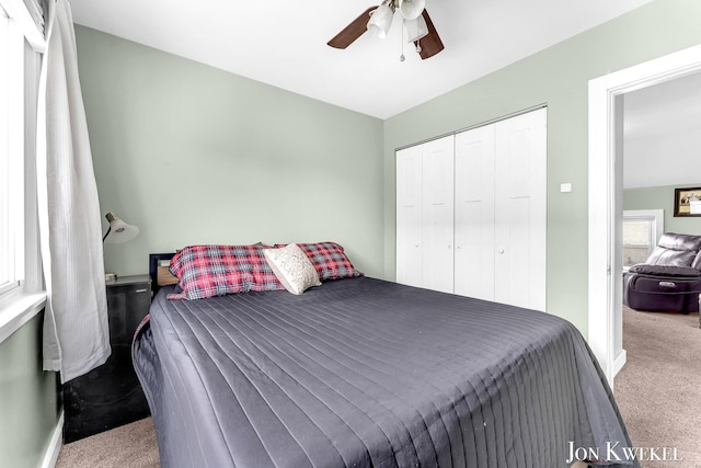 carpeted bedroom with ceiling fan and a closet