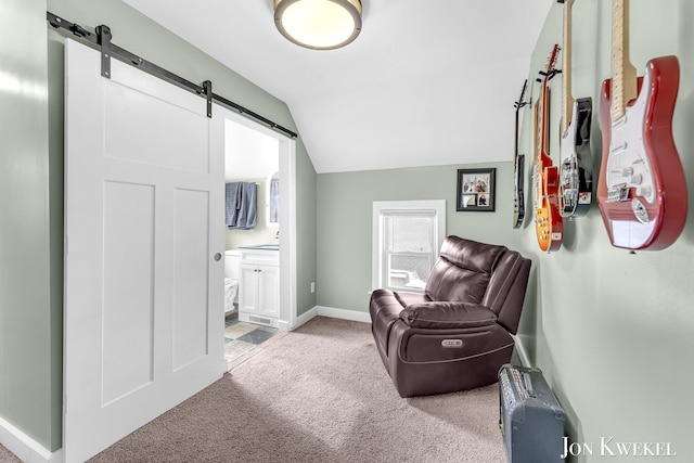 sitting room featuring light carpet, a barn door, baseboards, and lofted ceiling