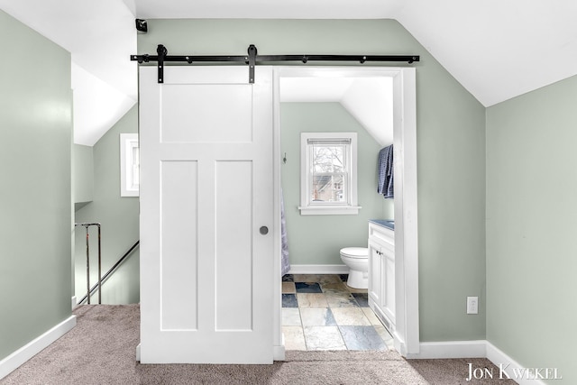 bathroom featuring lofted ceiling, toilet, vanity, and baseboards