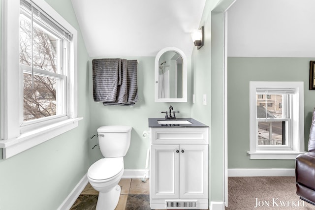 bathroom with lofted ceiling, toilet, visible vents, vanity, and baseboards