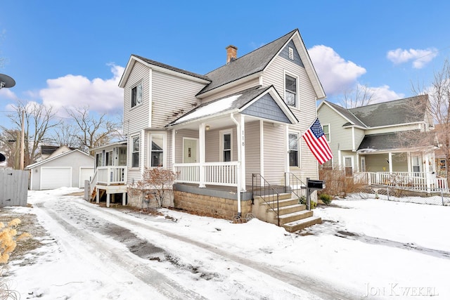 view of front of house with a detached garage, a chimney, a porch, and an outdoor structure