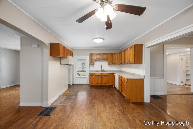 kitchen featuring visible vents, dark wood finished floors, brown cabinets, light countertops, and a sink