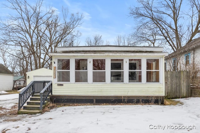 exterior space featuring an outbuilding, fence, and a garage