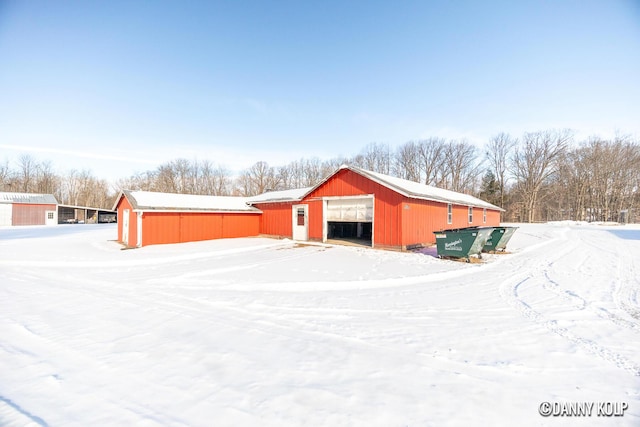 snow covered structure featuring an outbuilding