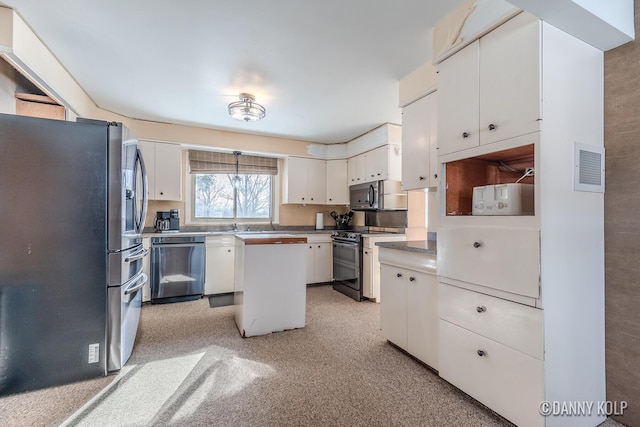 kitchen featuring appliances with stainless steel finishes, white cabinetry, a kitchen island, and visible vents