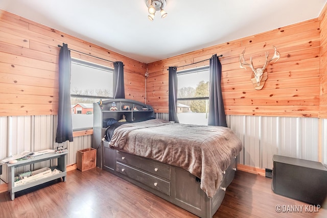 bedroom with wood walls and wood finished floors