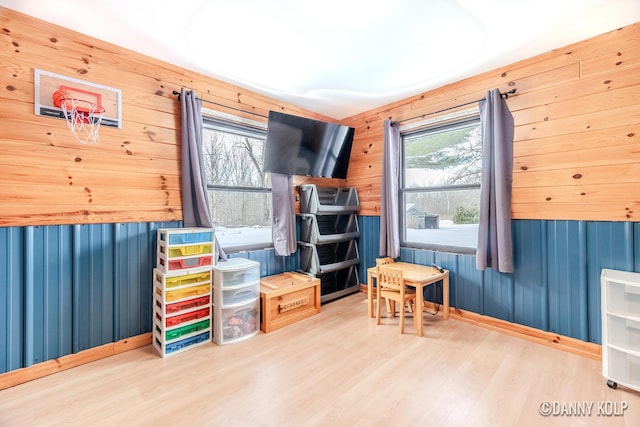 playroom featuring wooden walls and wood finished floors