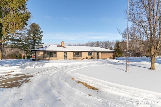 ranch-style house with a chimney and brick siding