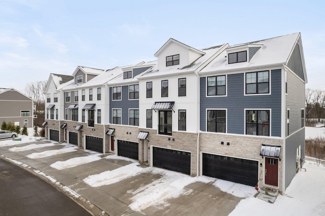 townhome / multi-family property with stone siding and an attached garage