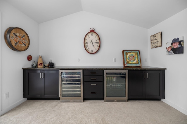 bar featuring a bar, beverage cooler, and lofted ceiling