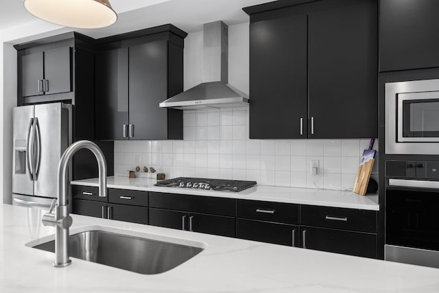 kitchen featuring stainless steel appliances, light countertops, dark cabinets, and wall chimney exhaust hood