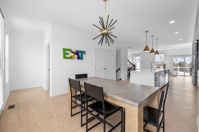 dining room with light wood finished floors, baseboards, visible vents, an inviting chandelier, and recessed lighting