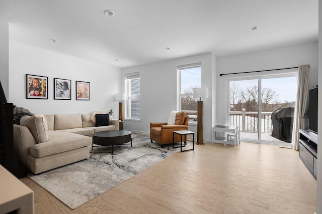 living area with light wood finished floors, baseboards, and recessed lighting