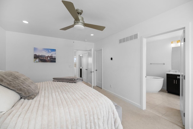 bedroom featuring ensuite bathroom, recessed lighting, light carpet, visible vents, and baseboards