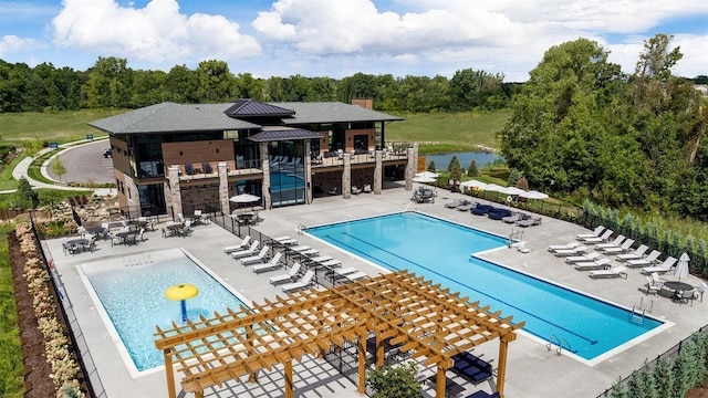 community pool with a patio area, a water view, fence, and a pergola