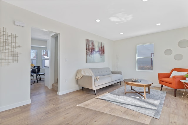 living area featuring light wood-type flooring, baseboards, and recessed lighting