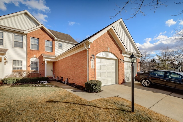 view of side of home with a garage, a yard, brick siding, and driveway