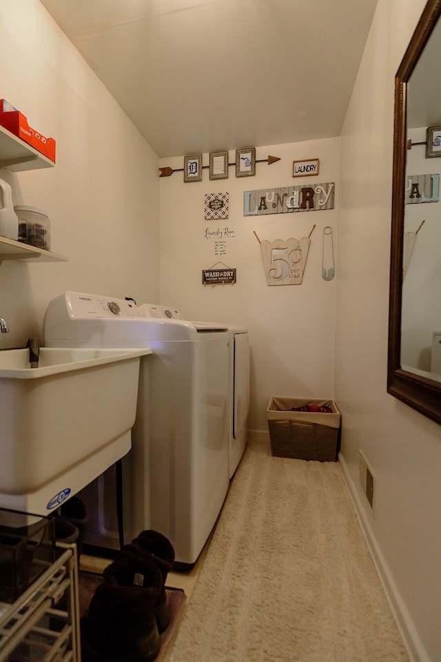 laundry area featuring light colored carpet, visible vents, washing machine and dryer, laundry area, and baseboards