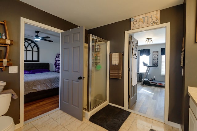 full bathroom featuring toilet, a stall shower, tile patterned flooring, and connected bathroom