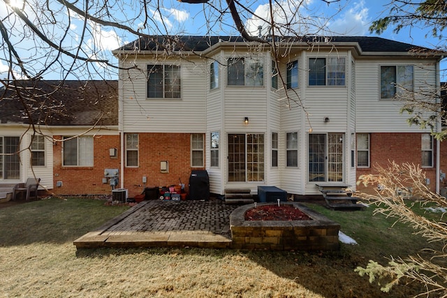 back of house with brick siding, a yard, a patio, entry steps, and central AC