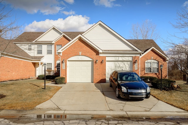 traditional home with a garage, driveway, and brick siding