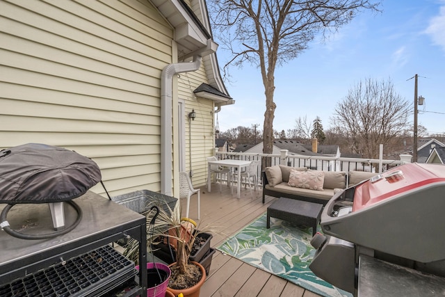 wooden deck with outdoor dining area and grilling area