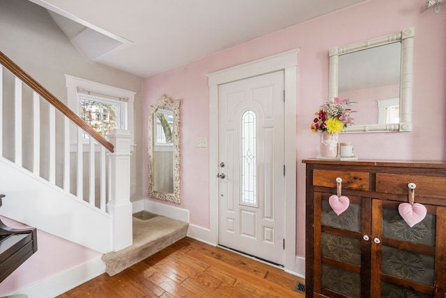 entrance foyer featuring hardwood / wood-style floors, stairway, and baseboards