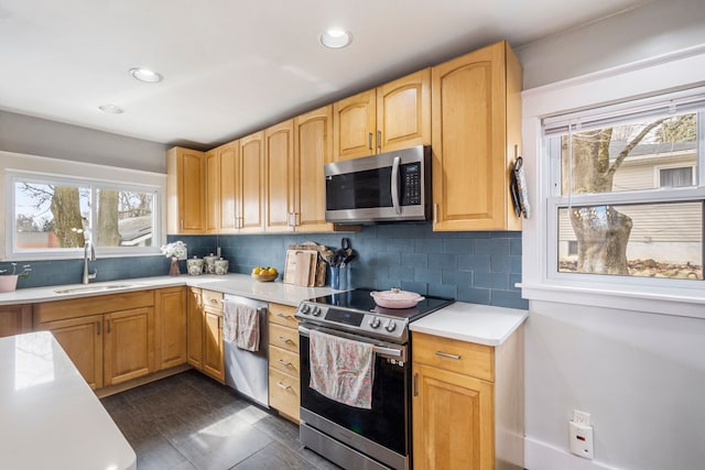 kitchen with a sink, decorative backsplash, appliances with stainless steel finishes, and light countertops