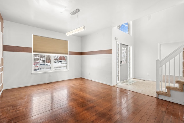 foyer featuring stairs, baseboards, visible vents, and light wood-style floors