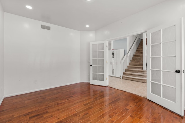 35316 Burgundy, Sterling Heights, MI 48312 - empty room with visible vents, baseboards, wood-type flooring, stairs, and french doors