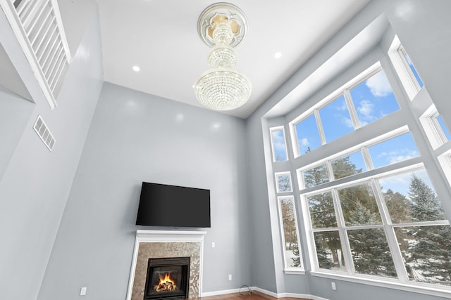 35316 Burgundy, Sterling Heights, MI 48312 - unfurnished living room featuring a tile fireplace, recessed lighting, a towering ceiling, visible vents, and an inviting chandelier