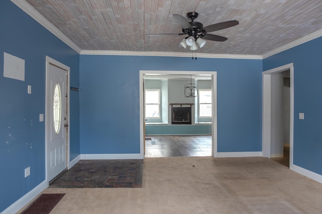 carpeted entryway with baseboards, a fireplace with raised hearth, wooden ceiling, ceiling fan, and crown molding