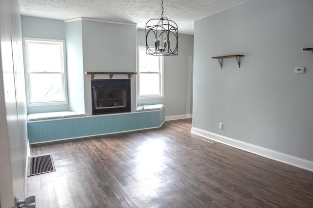 unfurnished living room featuring a fireplace with raised hearth, dark wood-style flooring, a textured ceiling, and visible vents