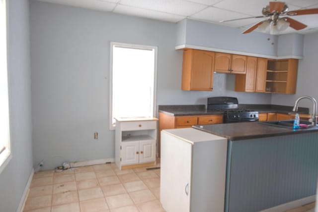 kitchen featuring open shelves, dark countertops, a paneled ceiling, black range with gas cooktop, and a sink