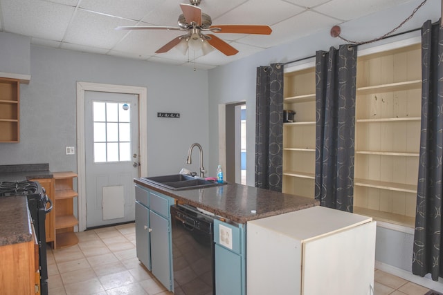 kitchen with a sink, black appliances, a drop ceiling, and an island with sink