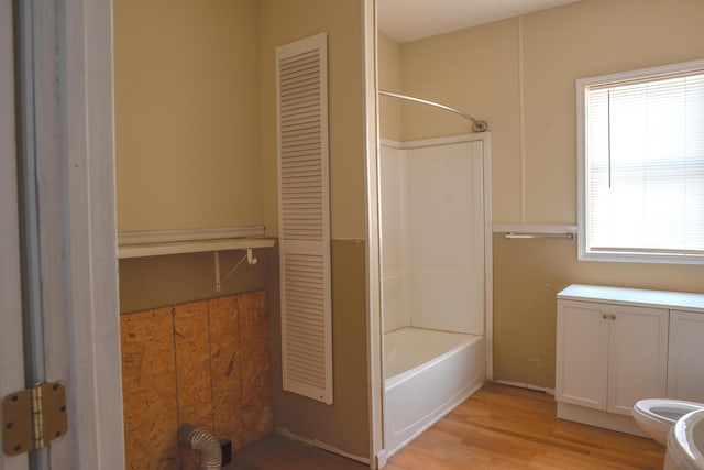 bathroom with shower / bathing tub combination, a closet, wood finished floors, and toilet