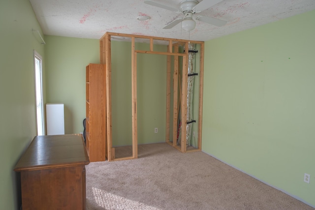 unfurnished bedroom featuring a closet, carpet flooring, ceiling fan, and a textured ceiling