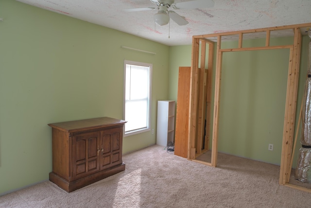 unfurnished bedroom featuring light carpet and a textured ceiling