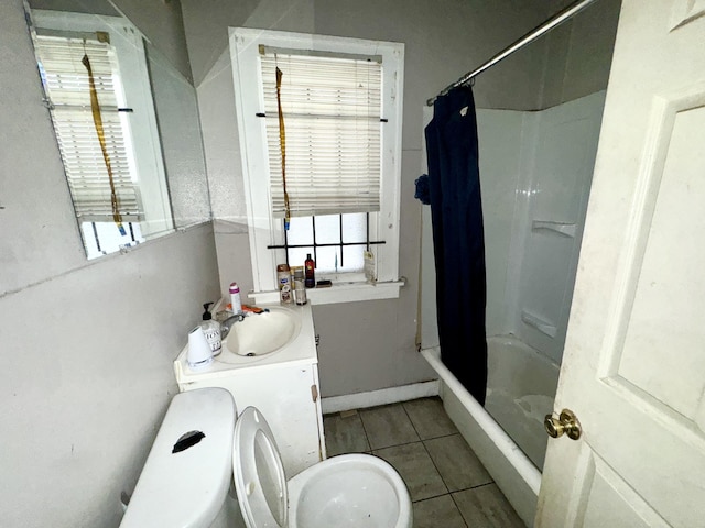 bathroom with shower / tub combo, a healthy amount of sunlight, tile patterned flooring, and vanity