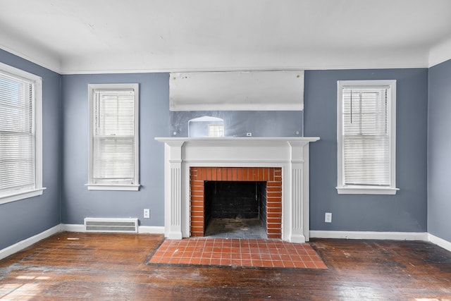 unfurnished living room with baseboards, a fireplace, visible vents, and dark wood-type flooring