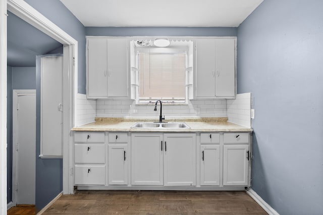 kitchen with light countertops, a sink, and white cabinets