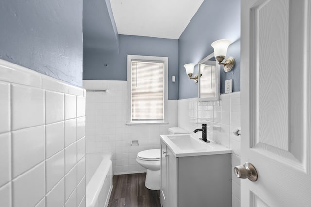 full bathroom with a washtub, tile walls, vanity, and toilet